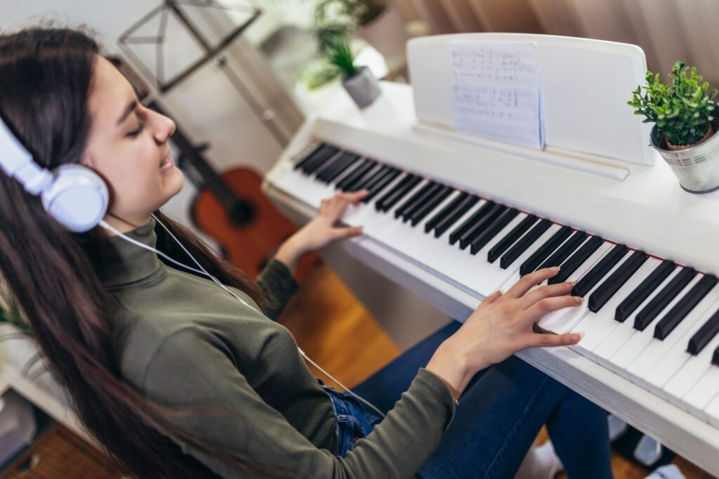 A young girl playing a keyboard, her fingers gracefully pressing the keys, deeply immersed in the music